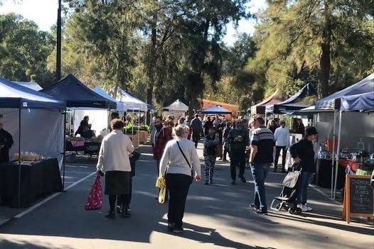 Shoppers wander through market stalls.