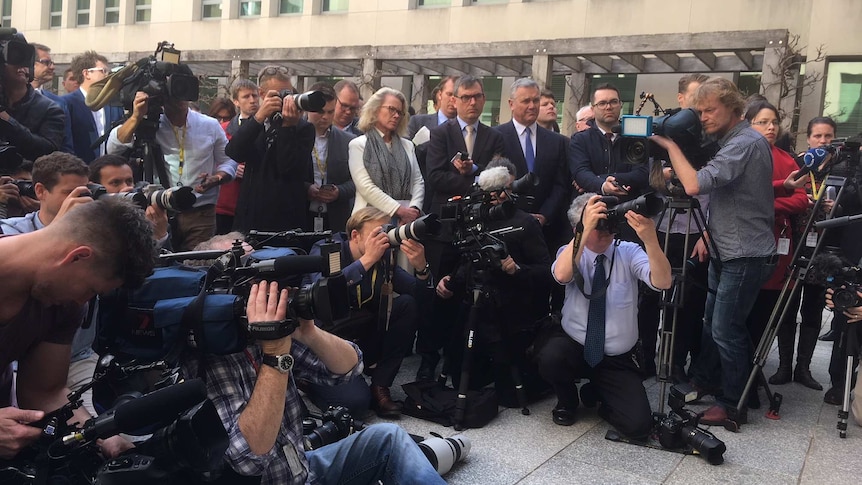 Group of camera operators, photographers and journalists gathering outside Parliament House.