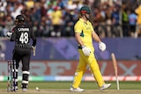 An Australian batsman lets his bat drop to the ground in disappointment after being dismissed in a match.