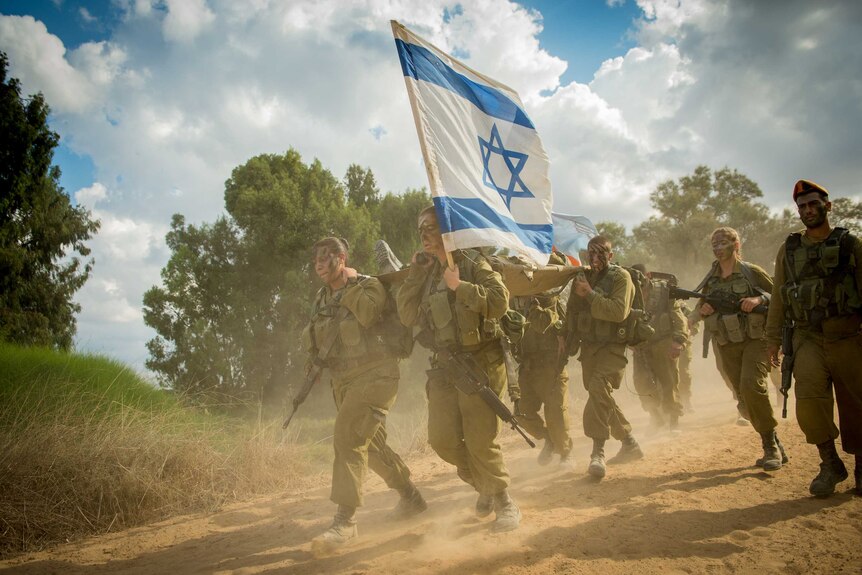 A group of Israeli solders carry a stretcher.