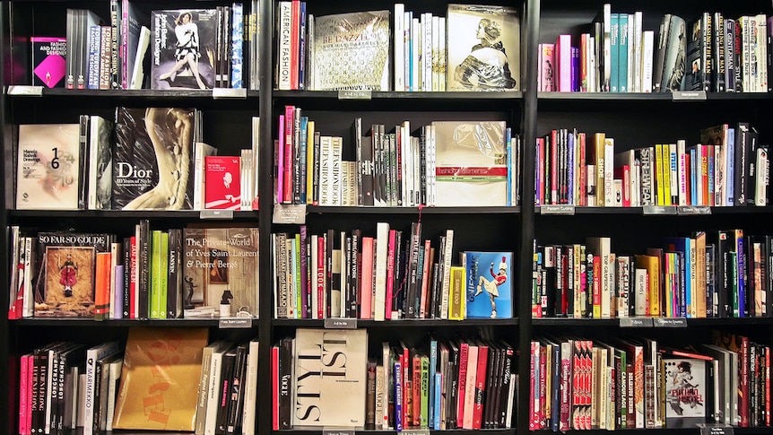 A selection of colourful books on shelves in a shop.