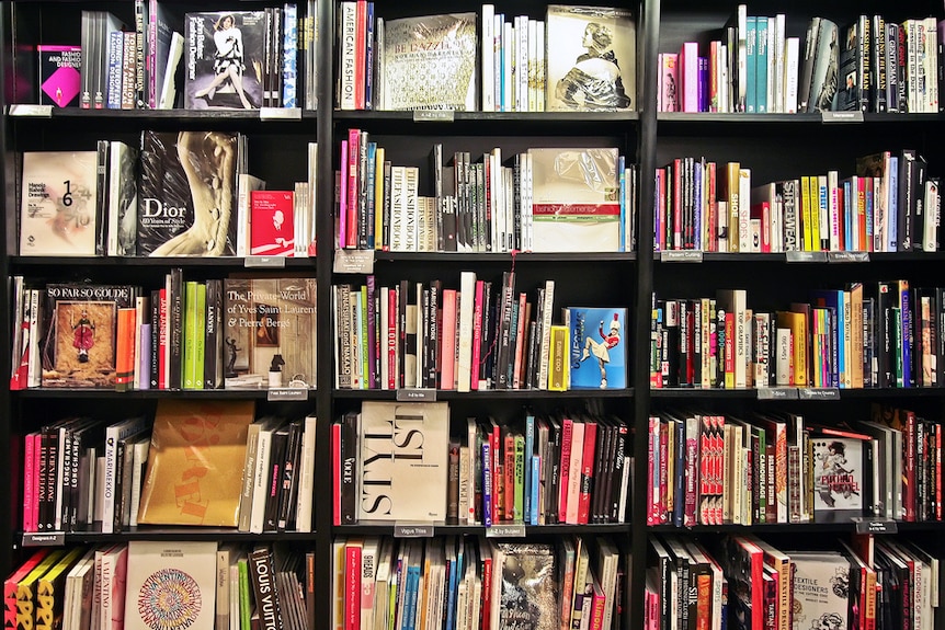 A selection of colourful books on shelves in a shop.