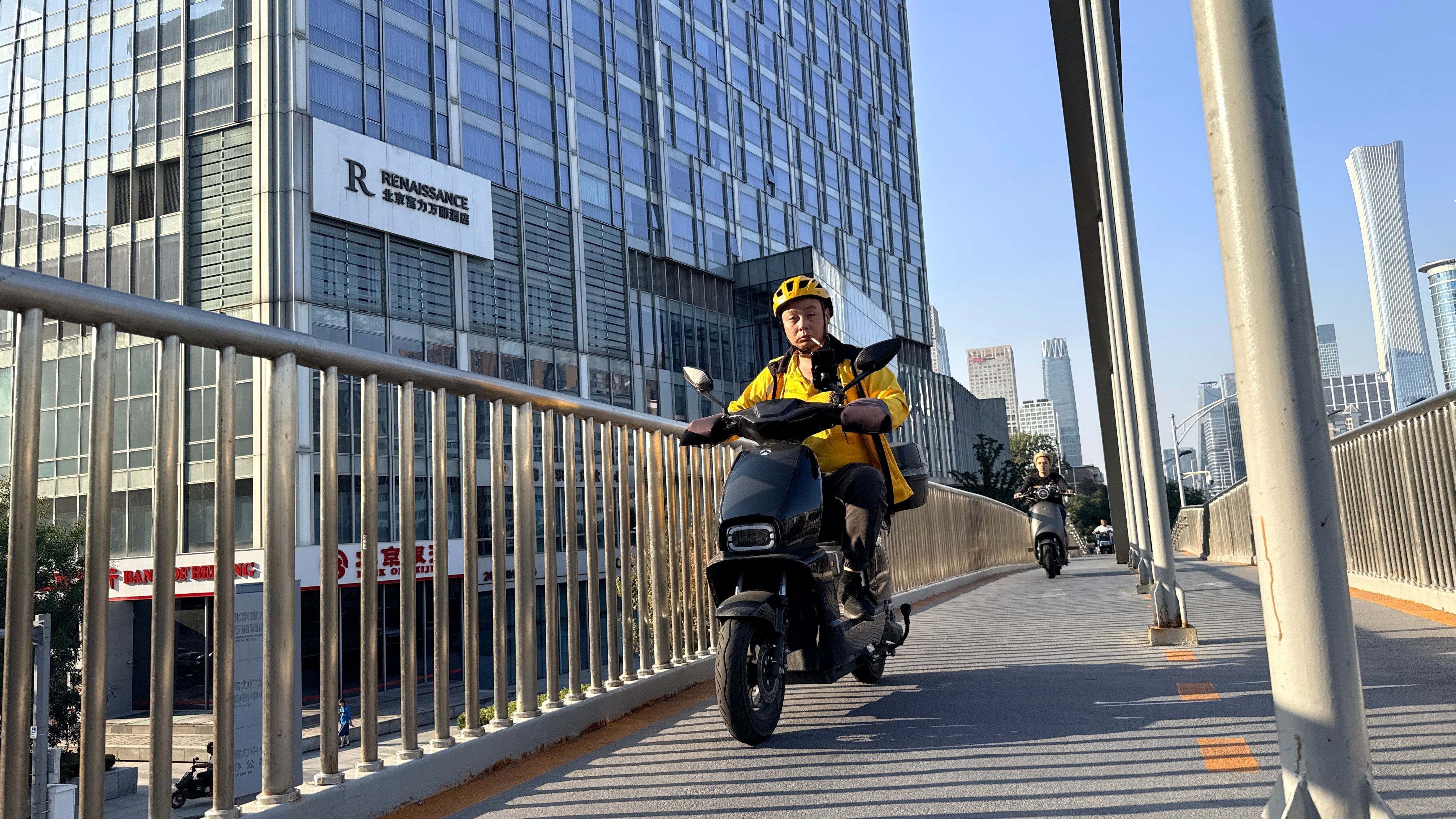 An elderly rider smoking a cigarette while riding on an overpass.