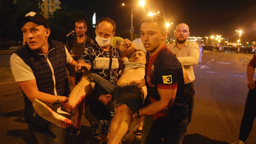 Protesters carry a wounded demonstrator during clashes with police after the Belarusian presidential election in Minsk.