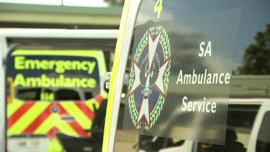 An SA Ambulance Service sign on the side of a vehicle with another in the background saying Emergency Ambulance