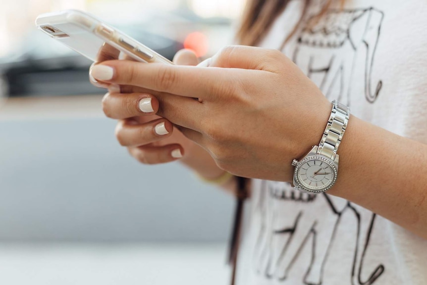 A woman uses a smartphone.