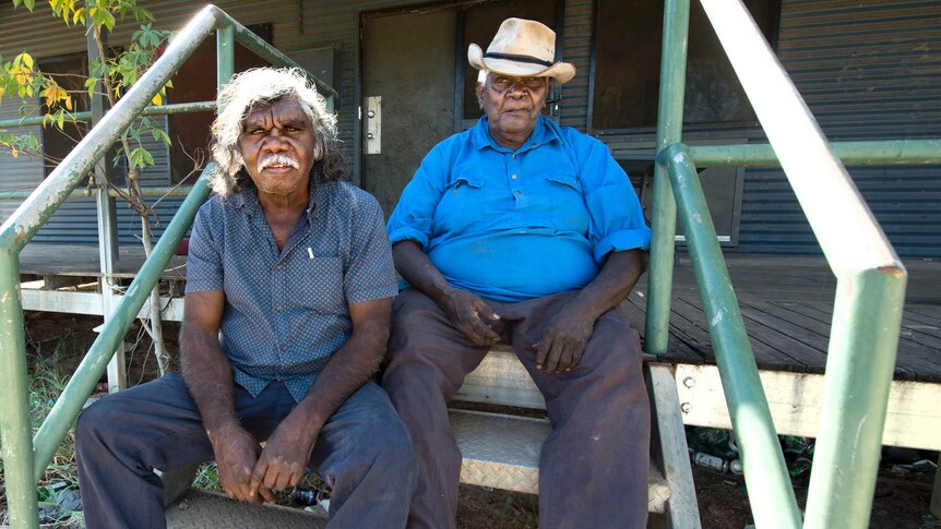 Senior Miriwoong man David Newry and Miriwoong elder Button Jones sit on a staircase.