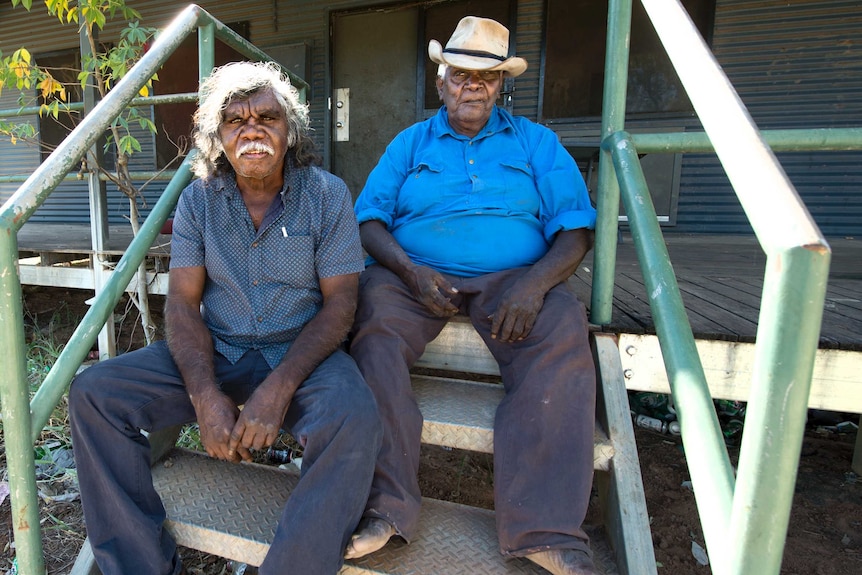 Senior Miriwoong man David Newry and Miriwoong elder Button Jones sit on a staircase.