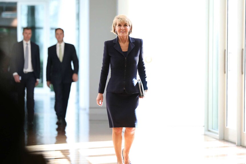 Julie Bishop marche seule dans un couloir du Parlement