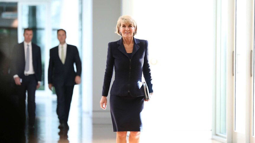 Julie Bishop walks alone down a hallway in parliament