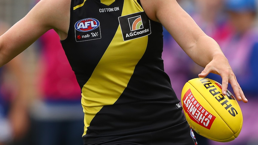 A general image of a Richmond AFLW plalyer about to kick the ball.