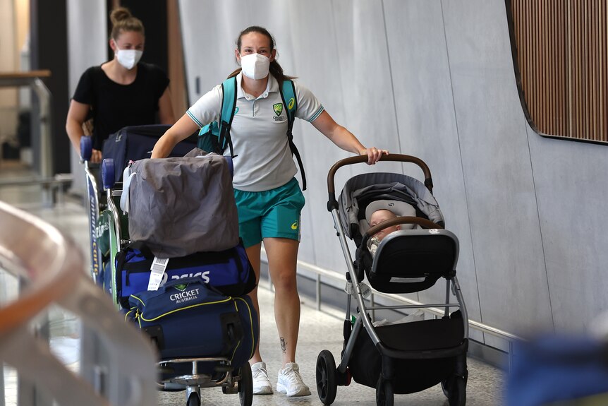 Schutt pushes her pram with one hand and a trolley loaded up with her cricket kits with the other