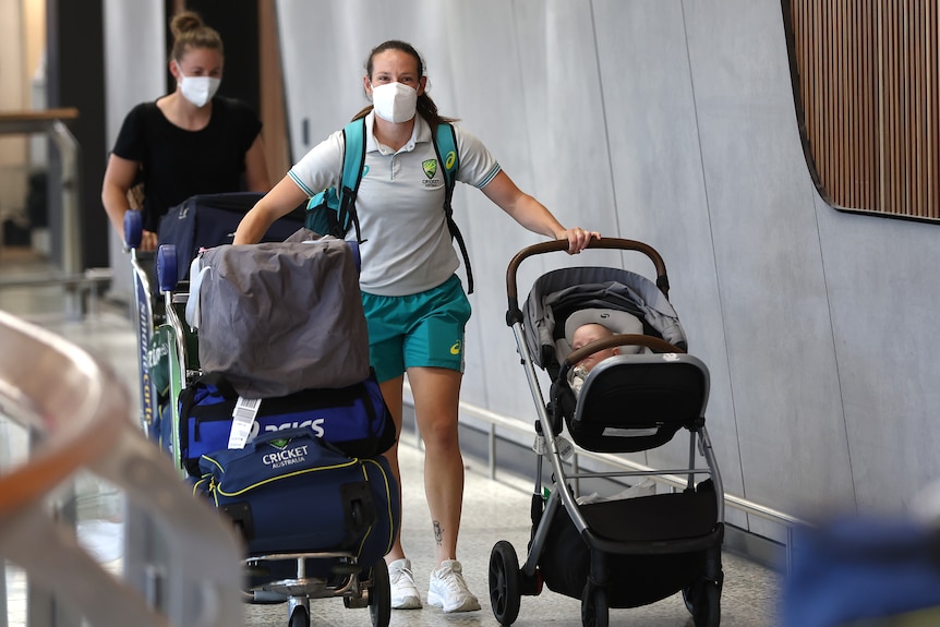 Schutt pushes her pram with one hand and a trolley loaded up with her cricket kits with the other