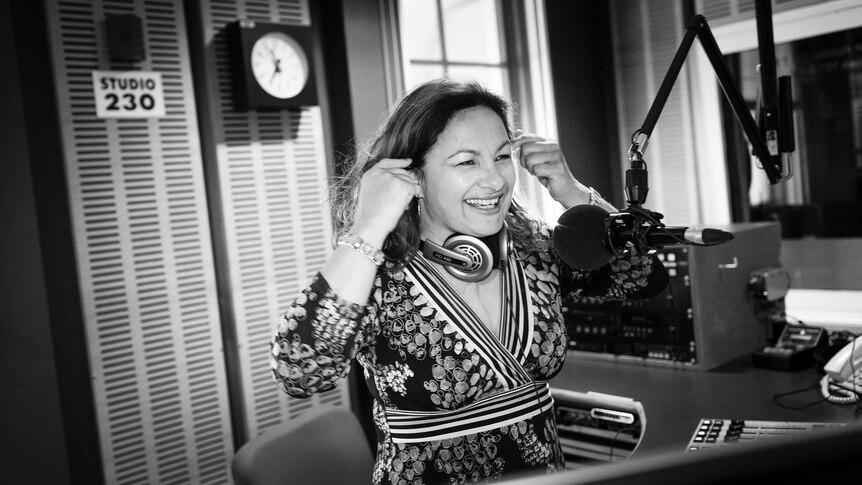 Black and white photo of Jill behind the microphone in radio studio.