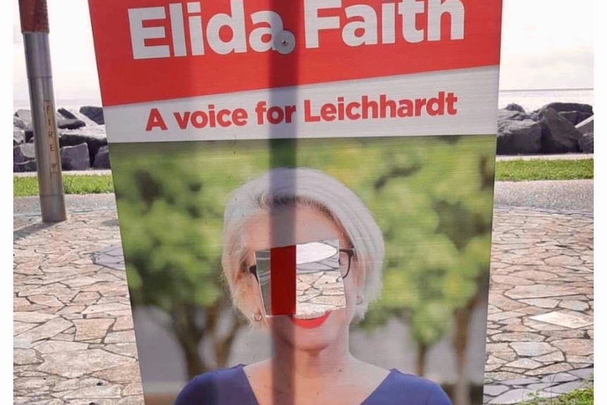 An election sign of a woman with a hole in the middle