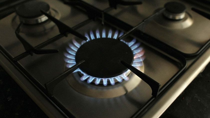 A gas burner burns on a stove