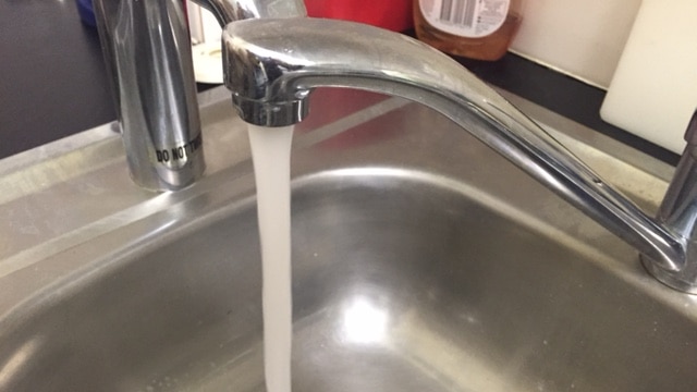 Water flows from a tap into a sink.