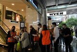 Shoppers queue outside a shopping centre in Sydney, all wearing face masks.
