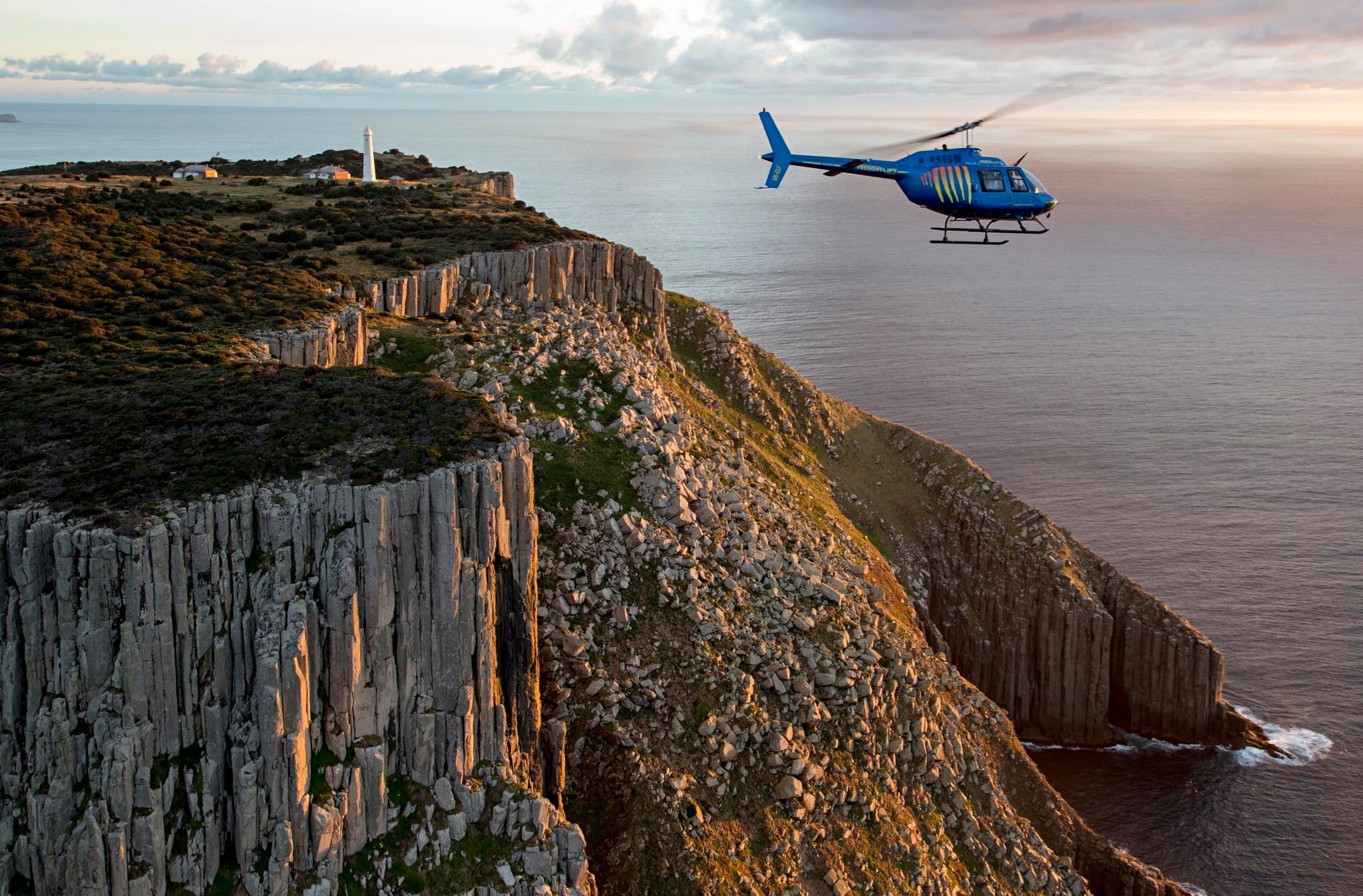 Rotor-lift chopper flying over cliffs