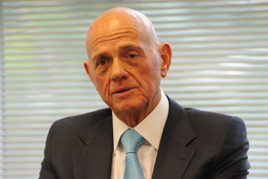 Head and shoulders shot of bald man in suit and tie