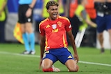 Lamine Yamal slides on his knees as he celebrates a goal for Spain against France at Euro 2024.