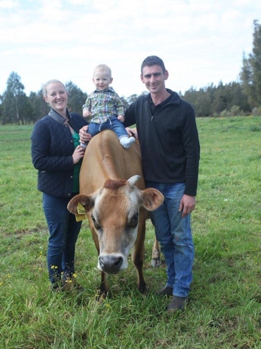 A man, woman and child with a cow.