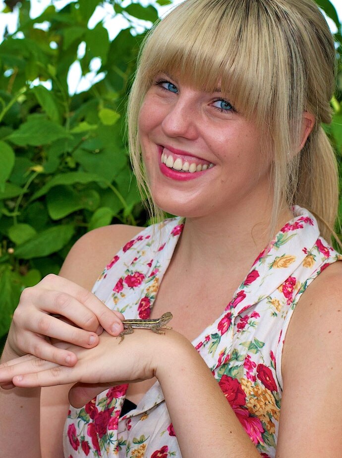Amelia Emmott holds the new species of dragon lizard named after her.