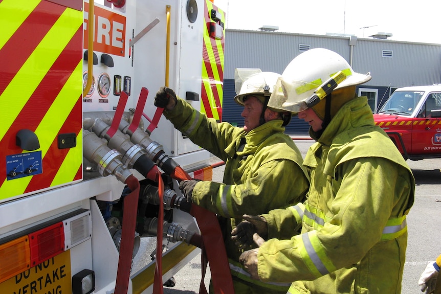 Tasmanian fire service pump truck with firefighters at rear