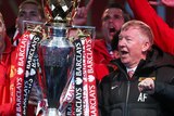 Sir Alex Ferguson celebrates with Manchester United players and Premier League trophy