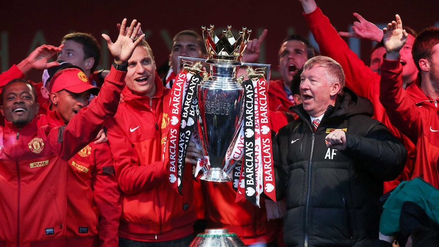 Sir Alex Ferguson celebrates with Manchester United players and Premier League trophy