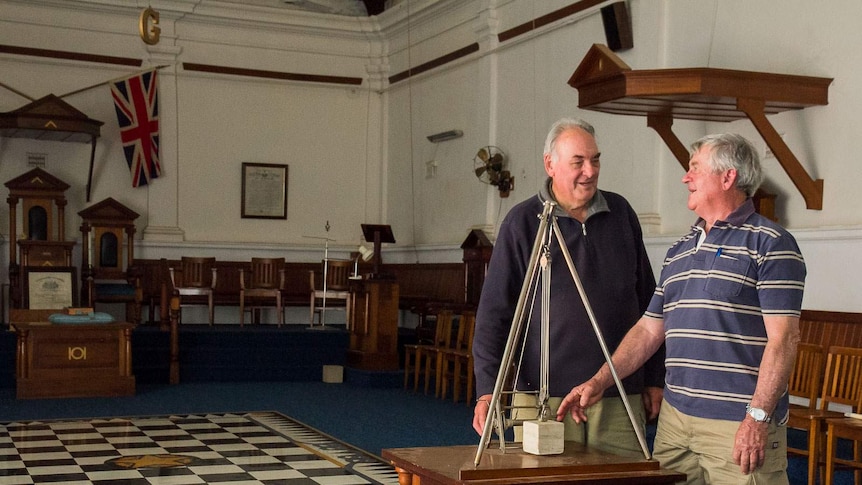 Masons Tony McKenzie and Wal Williams in the Masonic building at Forbes, NSW, with chequerboard tiles and ritual equipment.