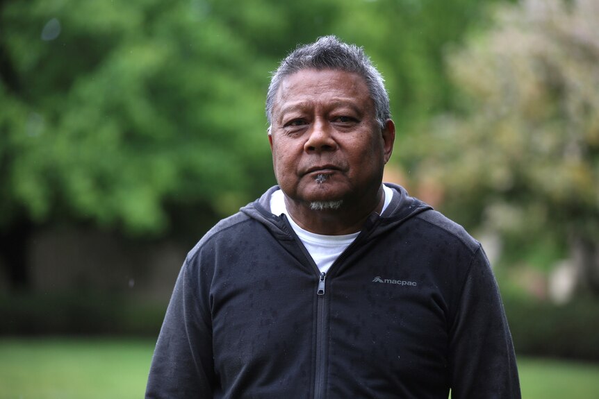 Peter Yu, an Aboriginal man with short greying hair, is pictured in casual clothes in a garden.