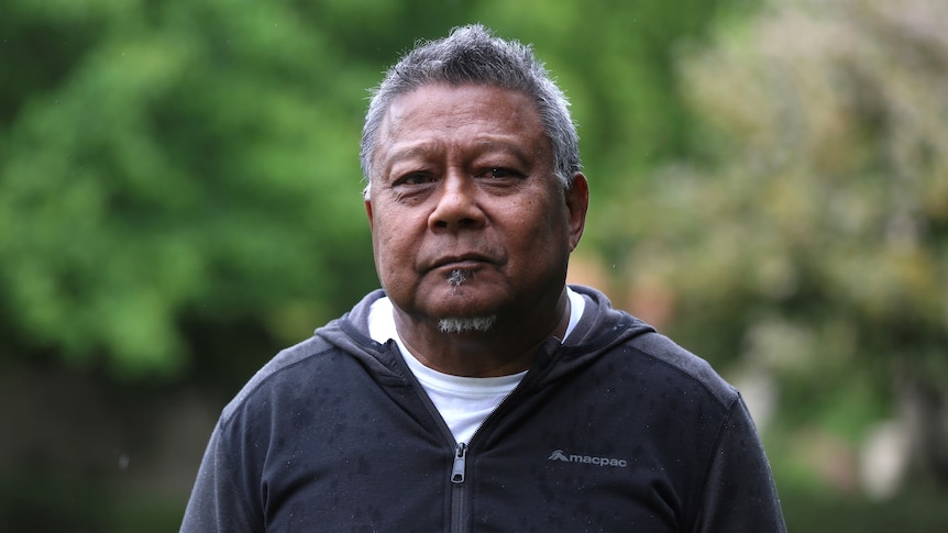 Peter Yu, an Aboriginal man with short greying hair, is pictured in casual clothes in a garden.
