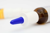 Glass nasal spray bottle with blue cap.