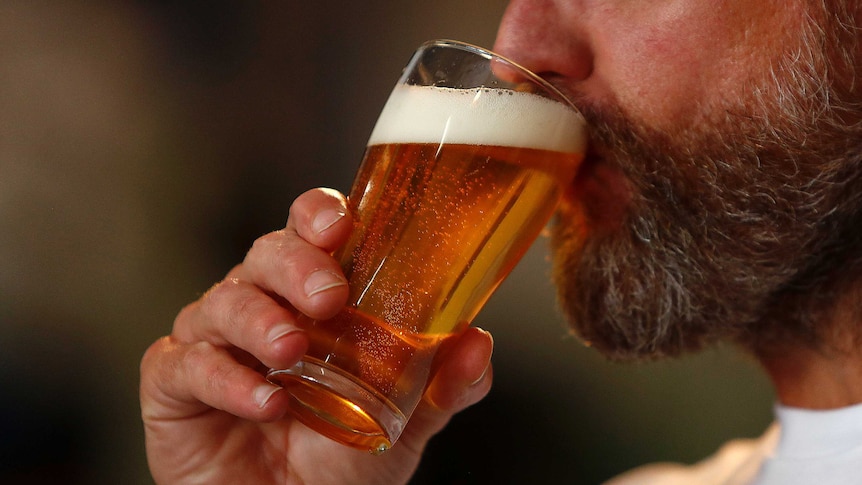 Man with beard drinking glass of beer