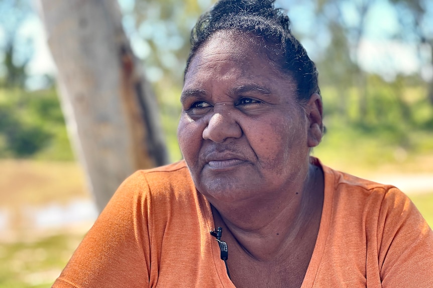 Belinda Boney looks off to the side of the camera, while sitting in front of a tree.