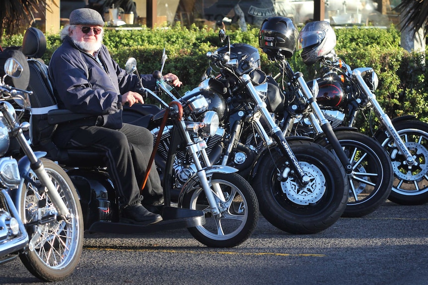 Man on mobility scooter among motorcycles