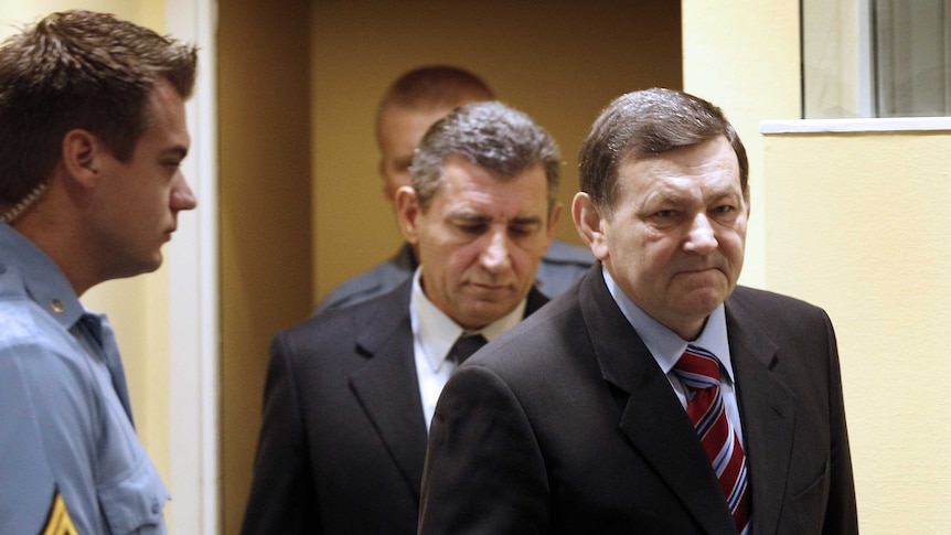 Former Croatian army generals Mladen Markac and Ante Gotovina walk into court.