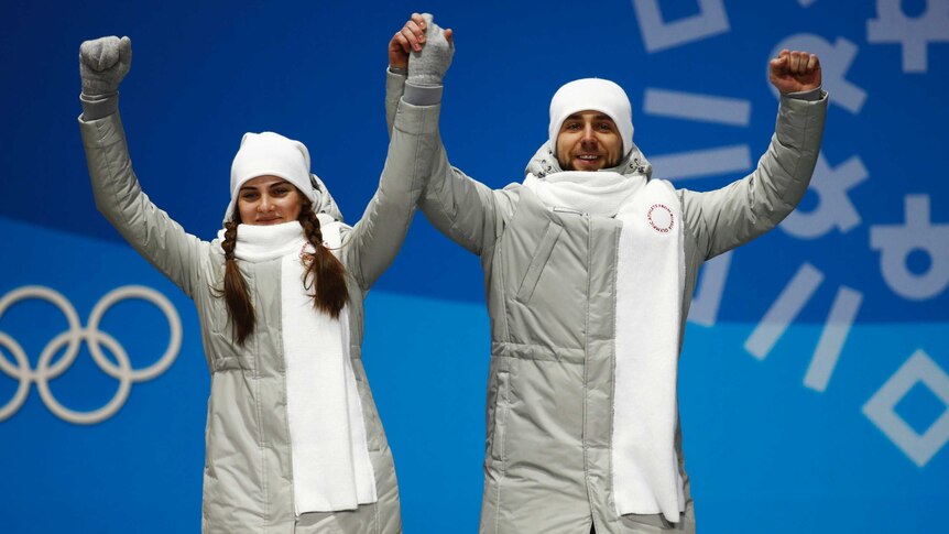 Russian curlers Anastasia Bryzgalova and Alexander Krushelnitsky celebrate Olympic bronze medals.
