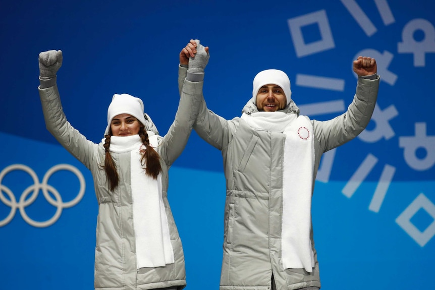 Russian curlers Anastasia Bryzgalova and Alexander Krushelnitsky celebrate Olympic bronze medals.