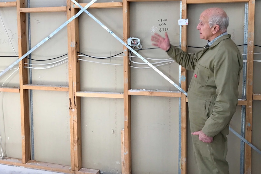 Tim Cox stands in front of an exposed wall at a house in the Rangeview estate.