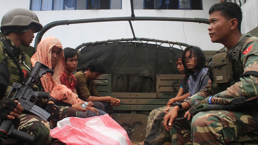 Philippine soldiers guarding members of the Maute extremist group