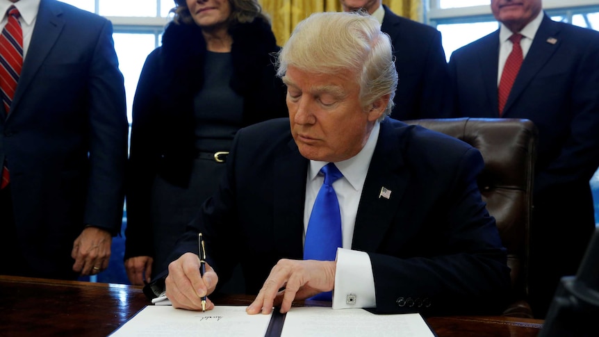 US President Donald Trump signs an executive order dealing with members of the administration lobbying foreign governments.