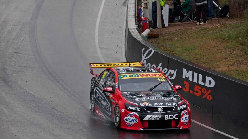 A car drives around Mt Panorama in the wet.