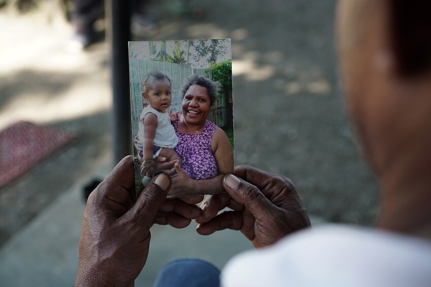 Saulo Honorobo holds a photo of his now deceased wife Marggeret.