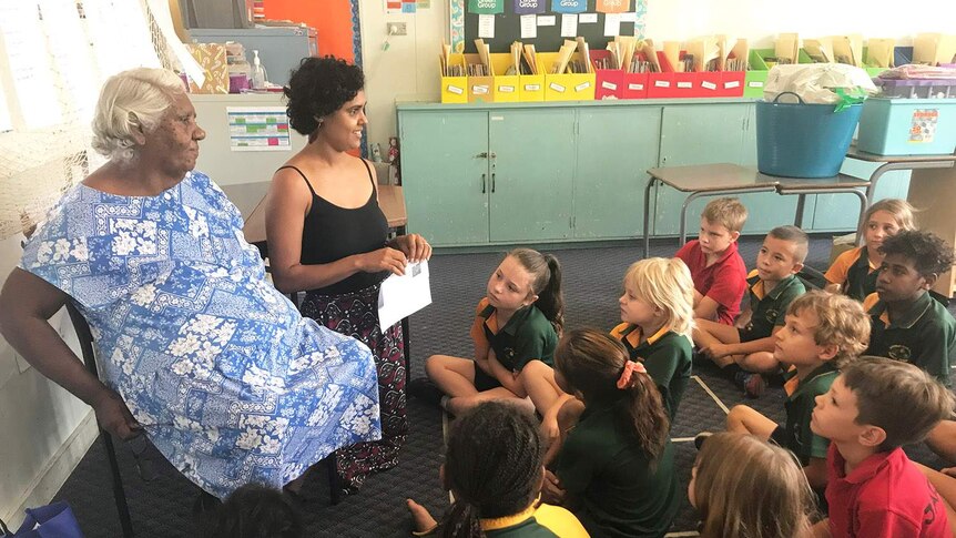 Students sit on floor of classroom at Mossman State School in far north Queensland, with teacher and Indigenous elder.