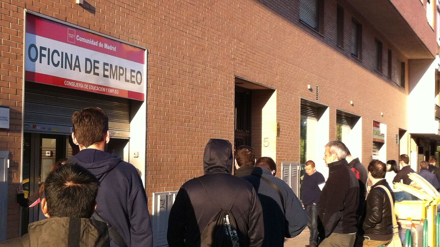 Spaniards queue outside an unemployment office