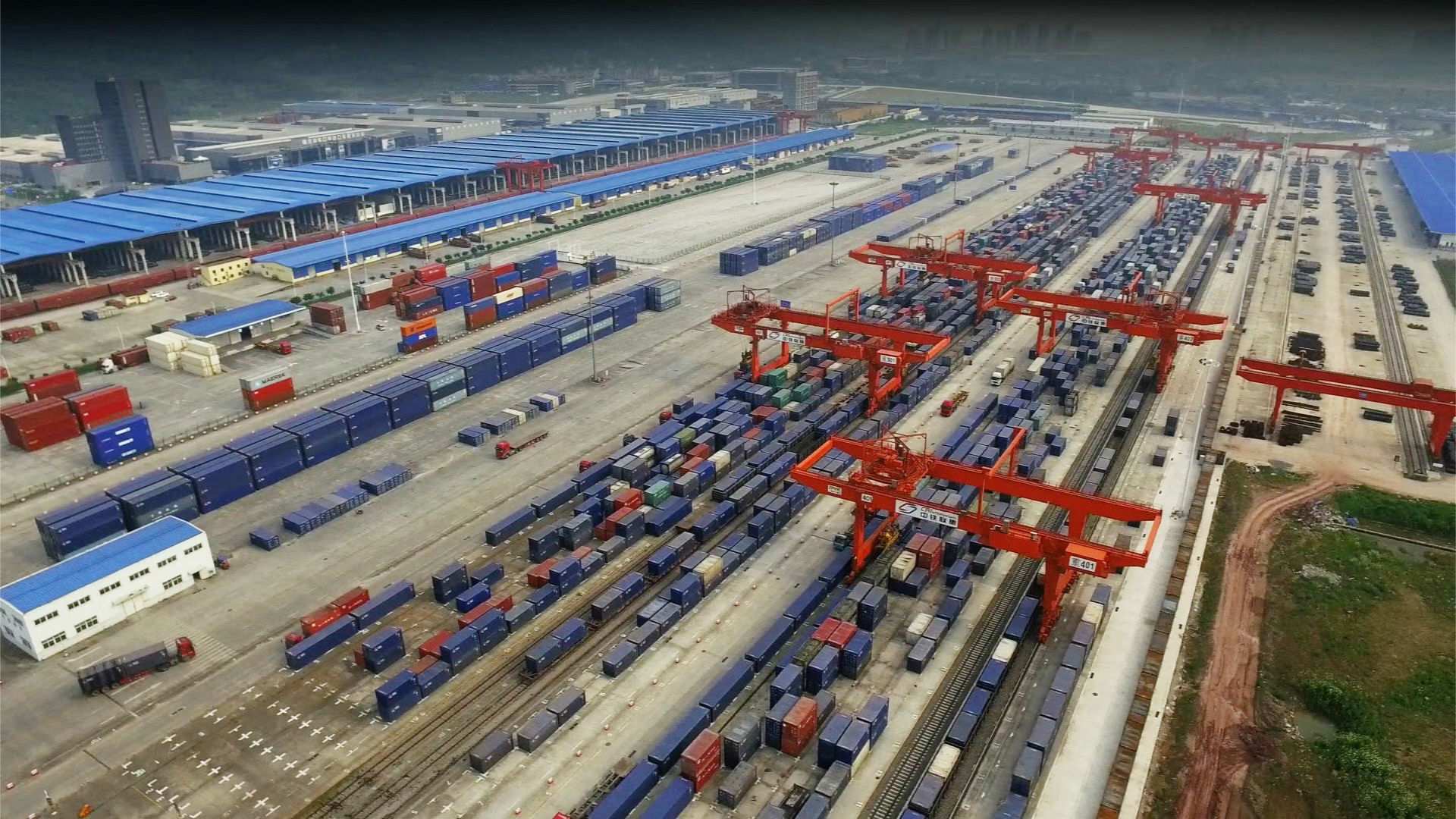 The logistics centre in the city of Chongqing, showing rows of shipping containers and the cranes to move them onto trains.
