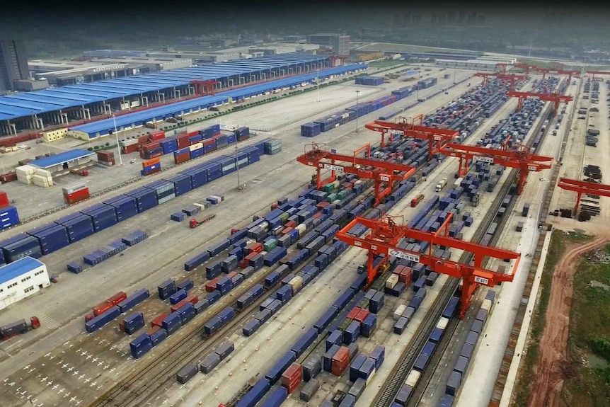 The logistics centre in the city of Chongqing, showing rows of shipping containers and the cranes to move them onto trains.