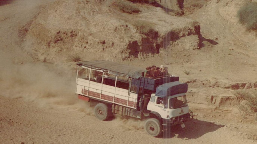 An aged holiday photo shows a truck driving through the desert.